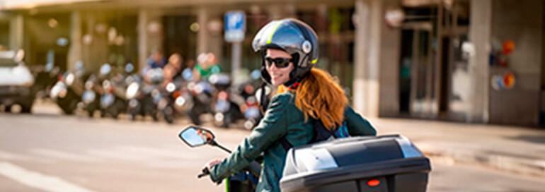 Pessoa de capacete em uma moto olhando para trás